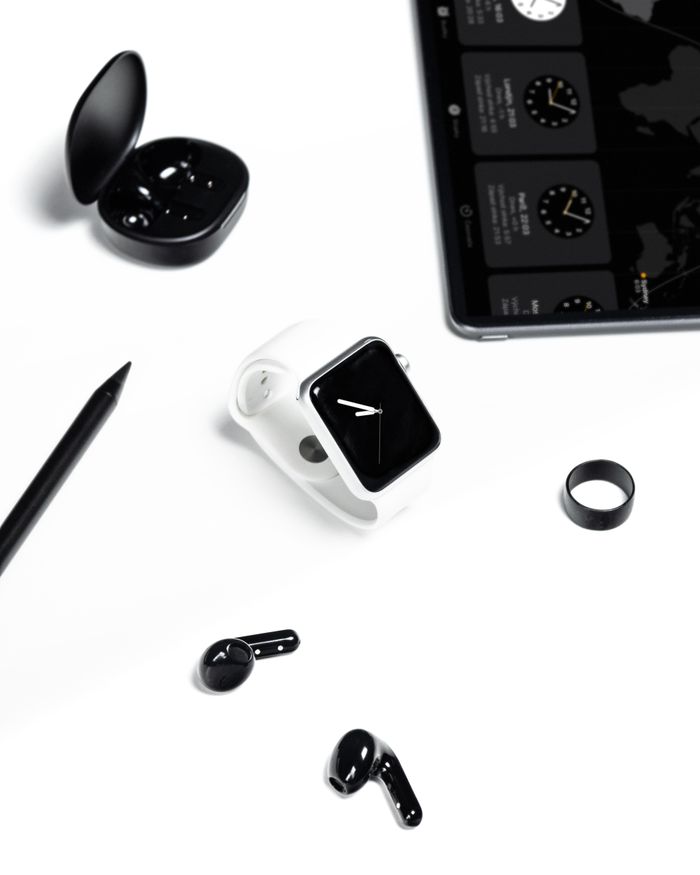 Stylish display of a modern workspace with gadgets like smartwatch, tablet, and headphones in a minimalist setting.